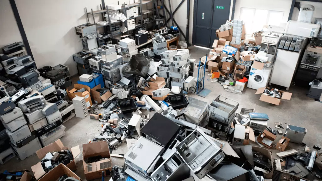 A cluttered room filled with various electronics, gadgets, and miscellaneous items scattered throughout the space.