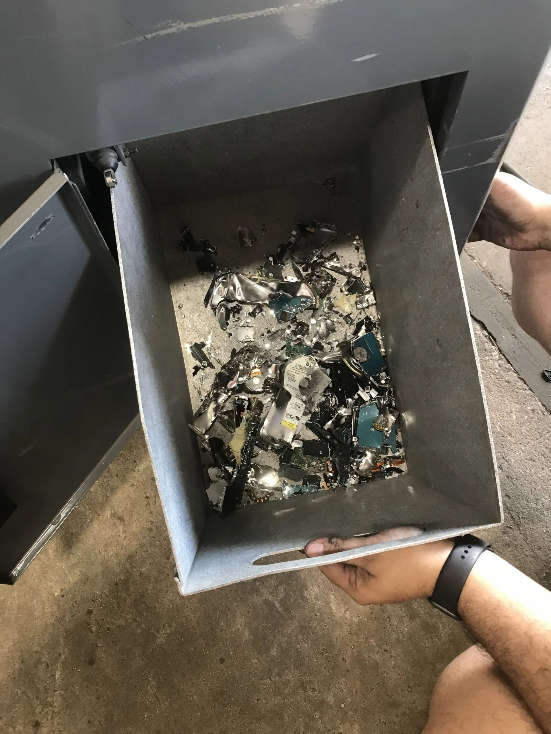 Shredded hard-drive fragments collected after on-site destruction.