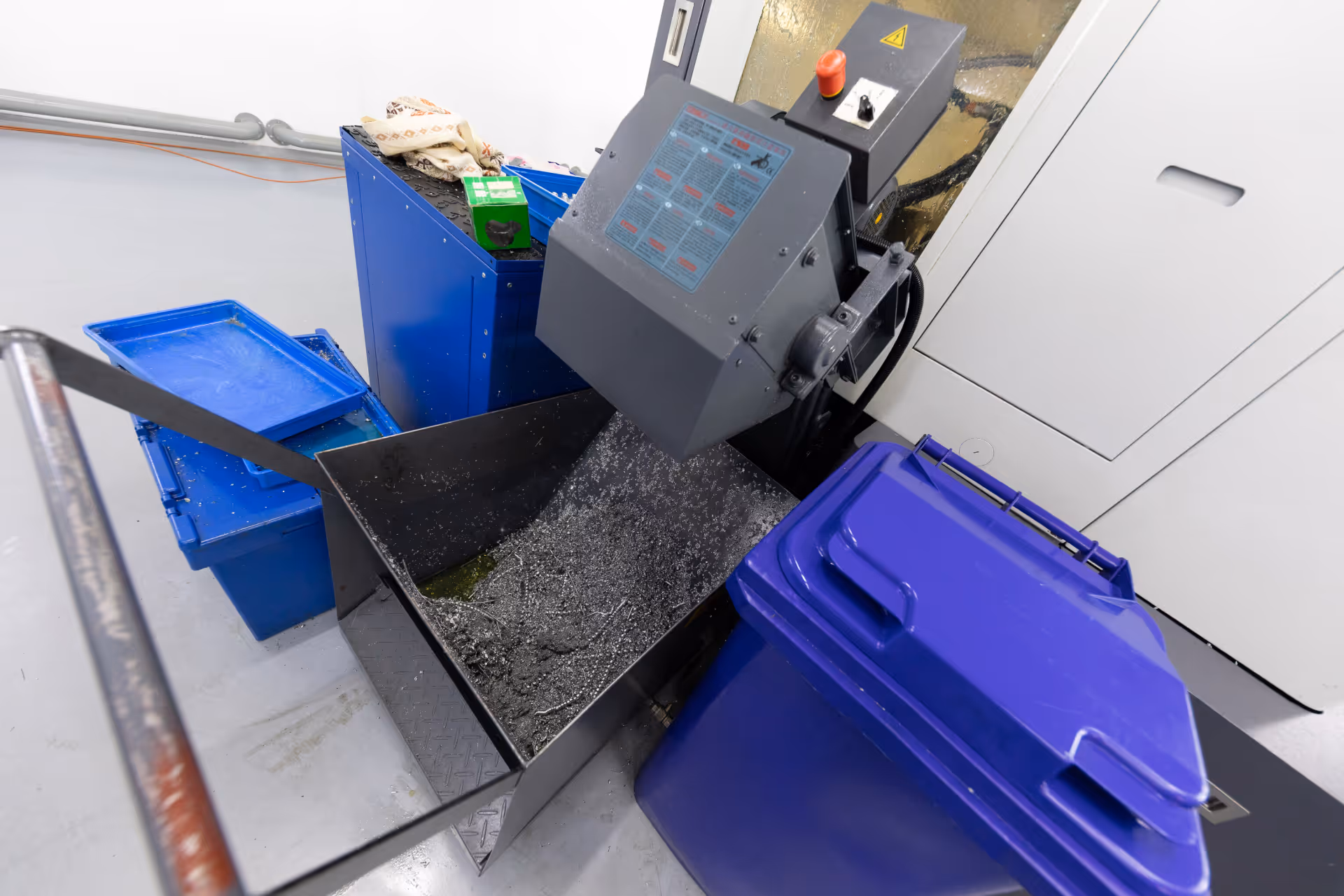 An industrial metal shredding machine with collection bins for scrap material.