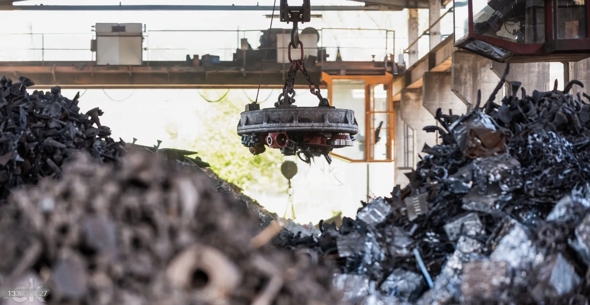 A crane is raising a significant amount of metal, emphasizing industrial activity and heavy equipment use.